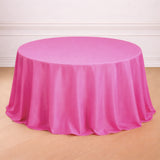 Pink tablecloth draped over a round table in a simple setting.