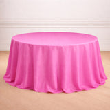 Round pink tablecloth on a wooden floor.
