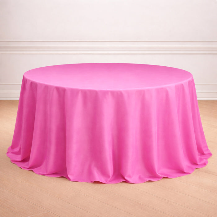 Round pink tablecloth on a wooden floor.