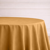 Round gold tablecloth on a table in an elegant setting.