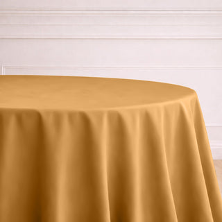Round gold tablecloth on a table in an elegant setting.