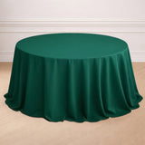 Green round tablecloth on a wooden floor.