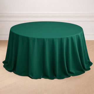 Green round tablecloth on a wooden floor.