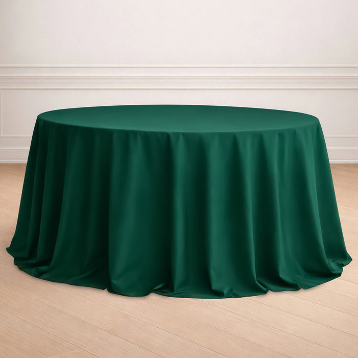 Green round tablecloth draped elegantly over a table in a staged setting.
