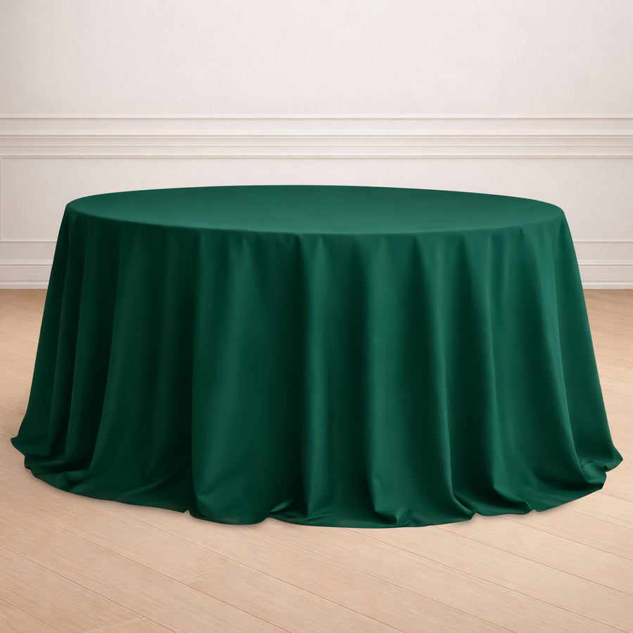 Green round tablecloth draped elegantly over a table in a staged setting.