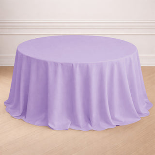 Round lavender tablecloth on a wooden floor.