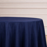 Navy blue round tablecloth on a plain backdrop