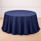 Navy blue tablecloth draped on a round table in a studio setting.