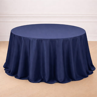 Navy blue tablecloth draped on a round table in a studio setting.