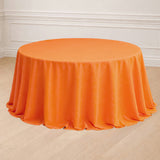 Round orange tablecloth with elegant draping.