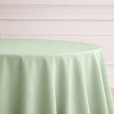Green tablecloth draped elegantly over a round table.
