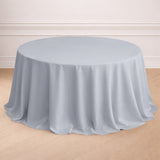 Round light gray tablecloth on a wooden floor.