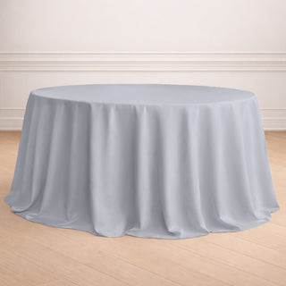 Round gray tablecloth on a wooden floor in an elegant setting.