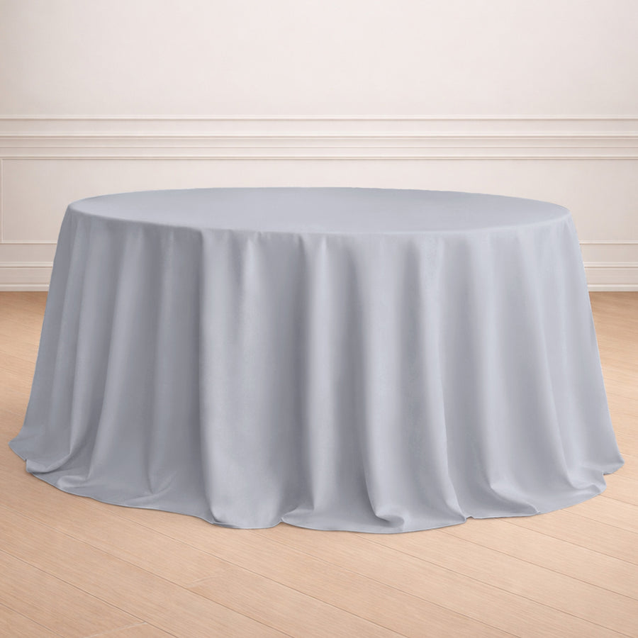 Round gray tablecloth on a wooden floor in an elegant setting.
