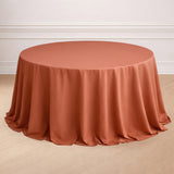 Round terracotta tablecloth draped elegantly over a circular table.