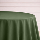 Green tablecloth draped over a round table in a soft setting.