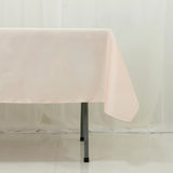 Pink tablecloth draping over a table edge against a light backdrop.