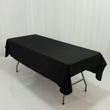 Black tablecloth draped over a folding table in a studio setting