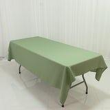 Green tablecloth draped over a folding table in a studio setting.