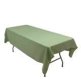 Green tablecloth draped over a folding table on a plain backdrop.