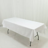 White table with a tablecloth on a plain backdrop