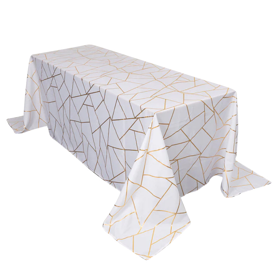 White tablecloth with gold geometric pattern, elegantly draped over a table.