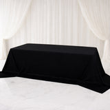Black tablecloth draped over a table in a studio setting.
