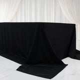 Black table covered with fabric in a minimalist setting.