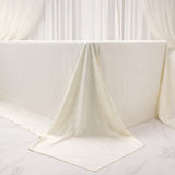 Elegant cream tablecloth draped over a table in a soft, neutral setting.