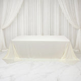 White tablecloth draped over a table with elegant curtains in the background.