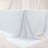 White table draped with smooth fabric, creating an elegant backdrop.