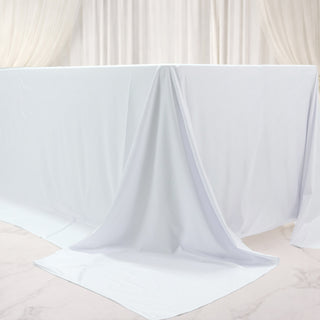 White table draped with smooth fabric, creating an elegant backdrop.