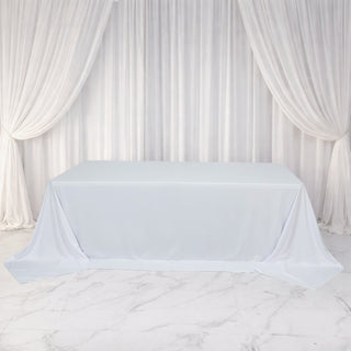 White tablecloth draped elegantly over a table in a soft, neutral setting.