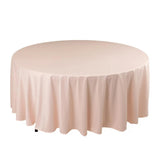 Round pink tablecloth with elegant draping on a plain backdrop.