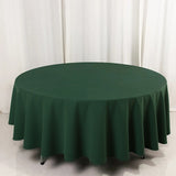 Green round tablecloth on a circular table against a plain backdrop