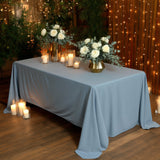 Elegant blue tablecloth set with floral arrangements and candles in a cozy ambiance.