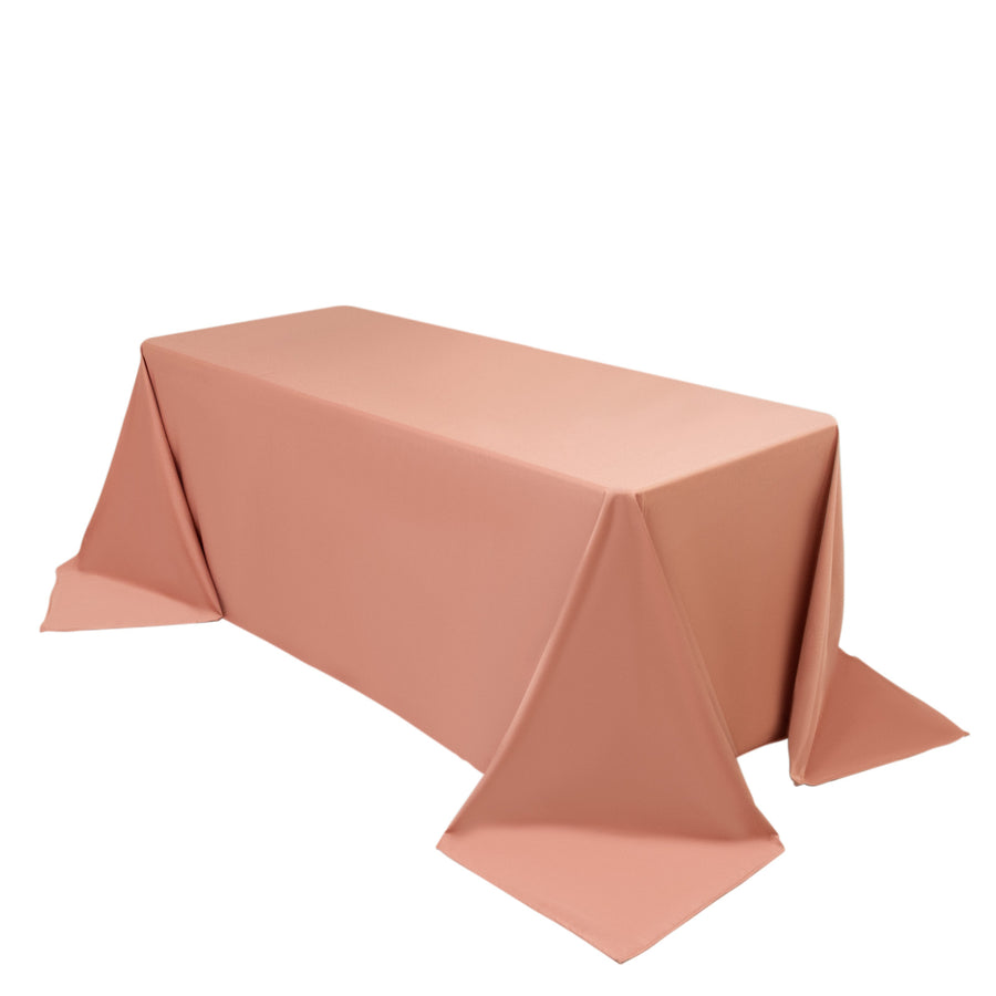 Pink tablecloth draped over a rectangular table in studio isolation.
