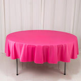 Round pink tablecloth draped over a table, showcasing vibrant color and smooth texture.