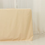 Beige tablecloth draping over a table in a minimalist setting.