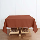 Brown tablecloth draped over a wooden table in a bright, minimal setting.