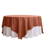 Rust-colored round tablecloth draped elegantly over a white table.