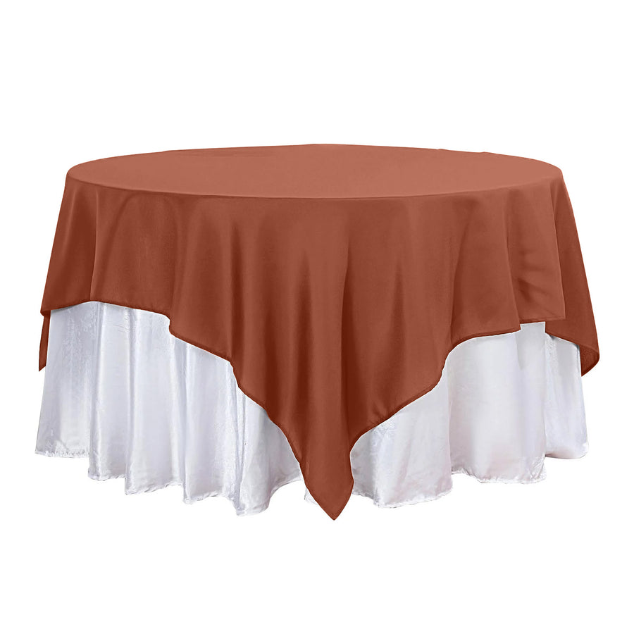 Round table with a brown tablecloth and white skirt.