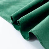 Green suede fabric close-up with folded edges and soft texture
