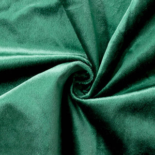 Emerald green velvet fabric close-up with soft folds and swirl texture#whtbkgd