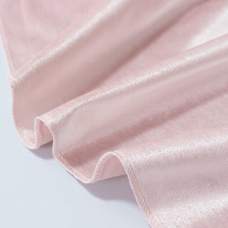 Light pink satin fabric close-up with soft ruffled folds