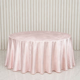 Round blush pink satin tablecloth on elegant banquet table backdrop