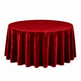 Round table with red velvet tablecloth on white background