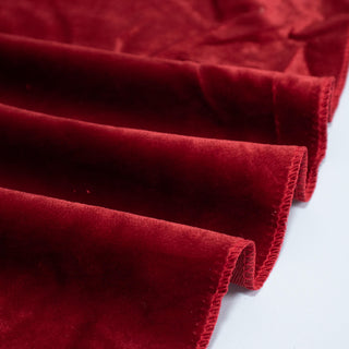 Red velvet fabric folds close-up on a white background
