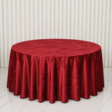 Red velvet round tablecloth on a large banquet table in a bright room