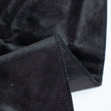 Black velvet fabric close-up with stitched seam and folded edge